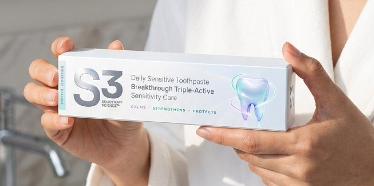 Hands holding the S3 Daily Sensitive Toothpaste box in a bathroom